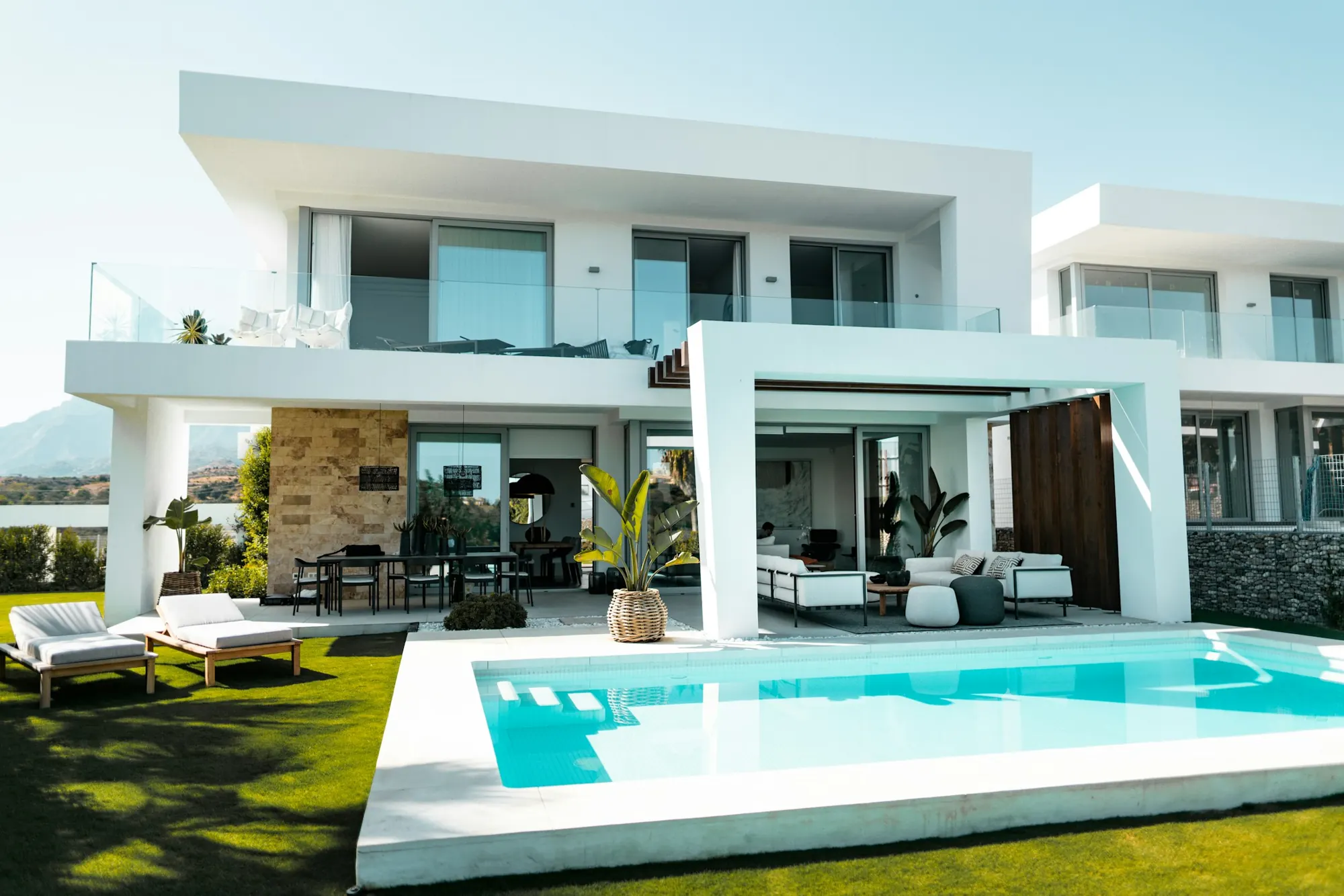 Villa blanca de dos pisos con piscina y terraza techada